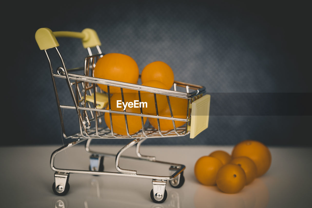 CLOSE-UP OF ORANGE FRUITS IN BASKET