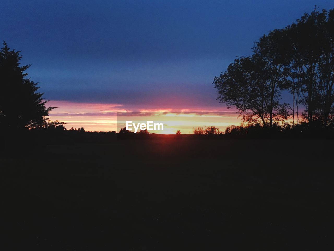 SCENIC VIEW OF SILHOUETTE LANDSCAPE AGAINST SKY AT SUNSET