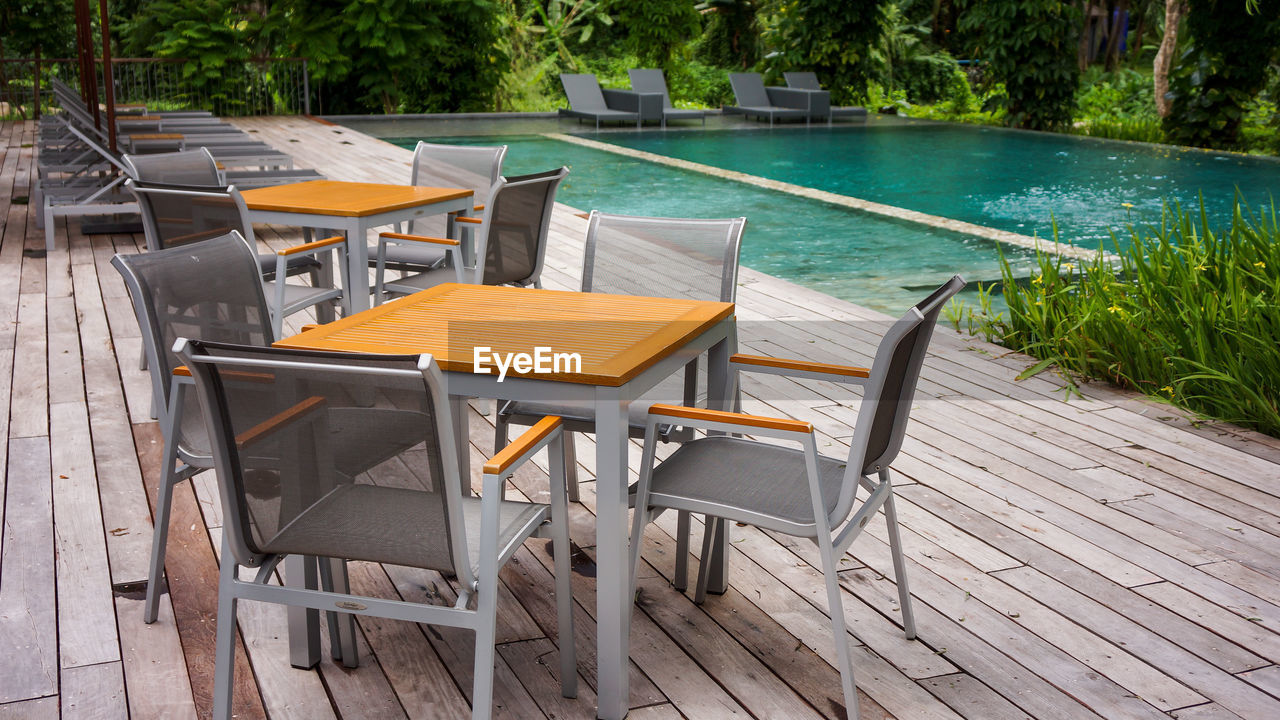 Empty tables and chairs at poolside