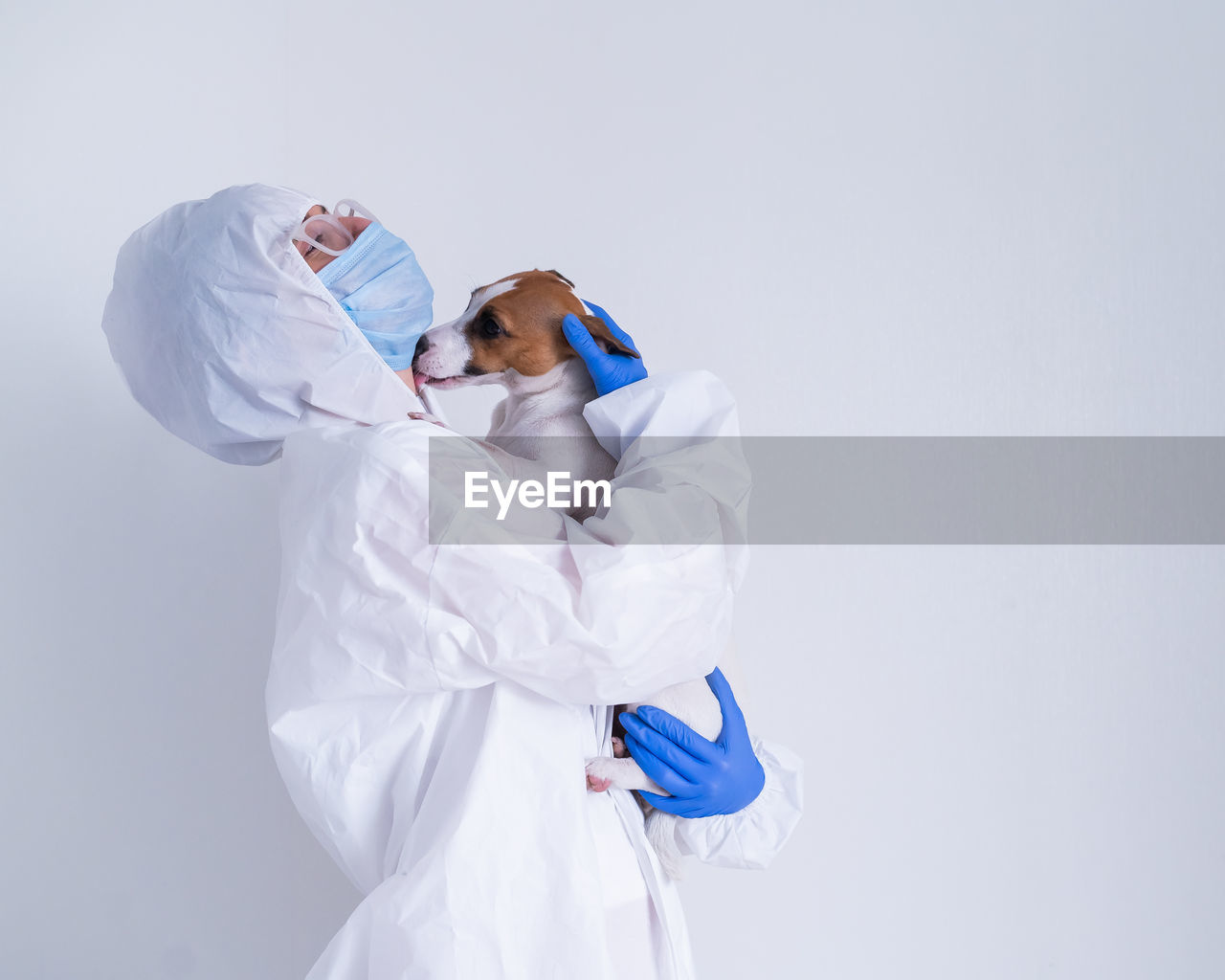 REAR VIEW OF TWO WOMEN STANDING AGAINST WHITE BACKGROUND