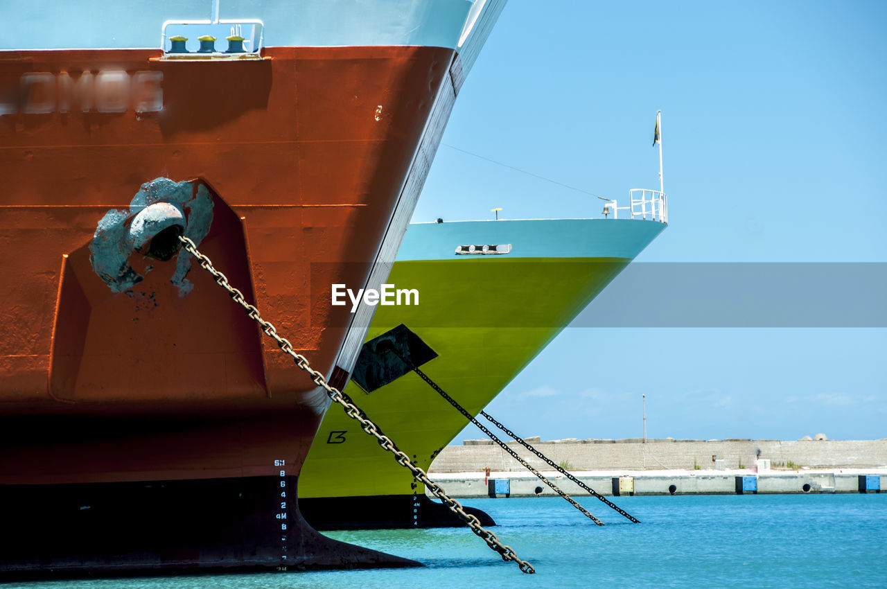 Ships moored in sea against clear sky