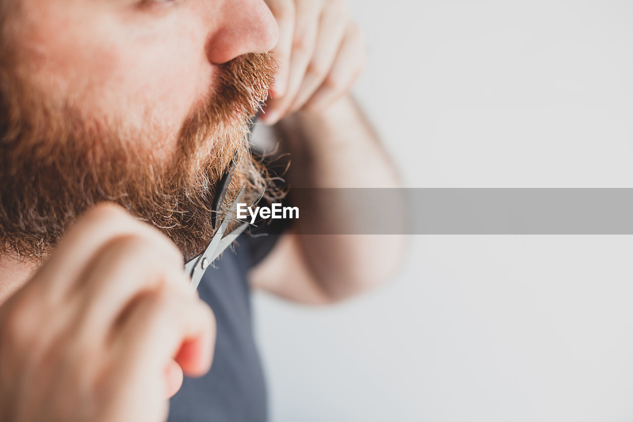 Close-up of man cutting mustache