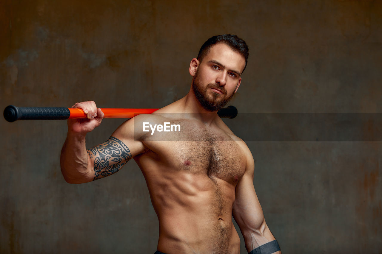 Portrait of young man exercising in gym