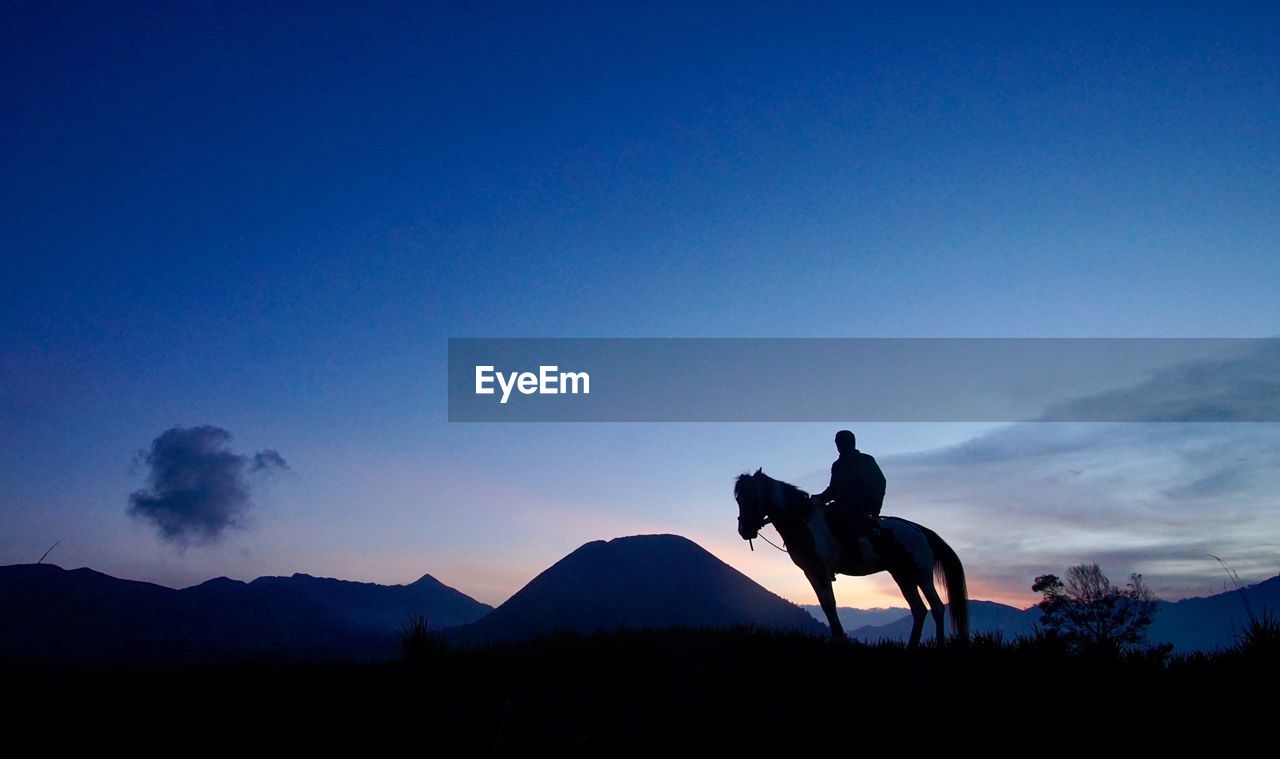 Bromo horseman in silhouette during sunrise 