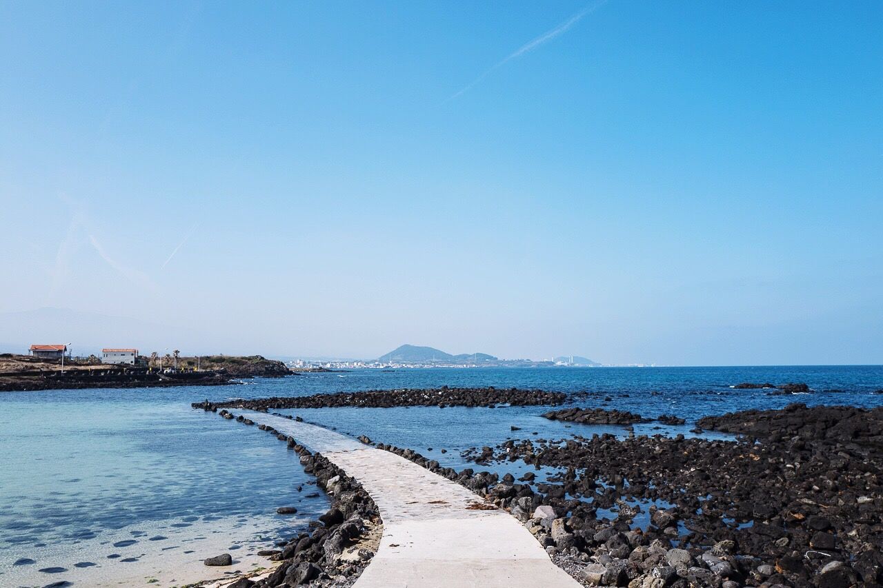 Pier by sea against blue sky