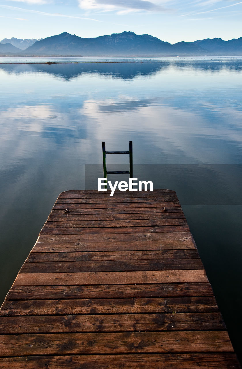 Jetty in lake against sky