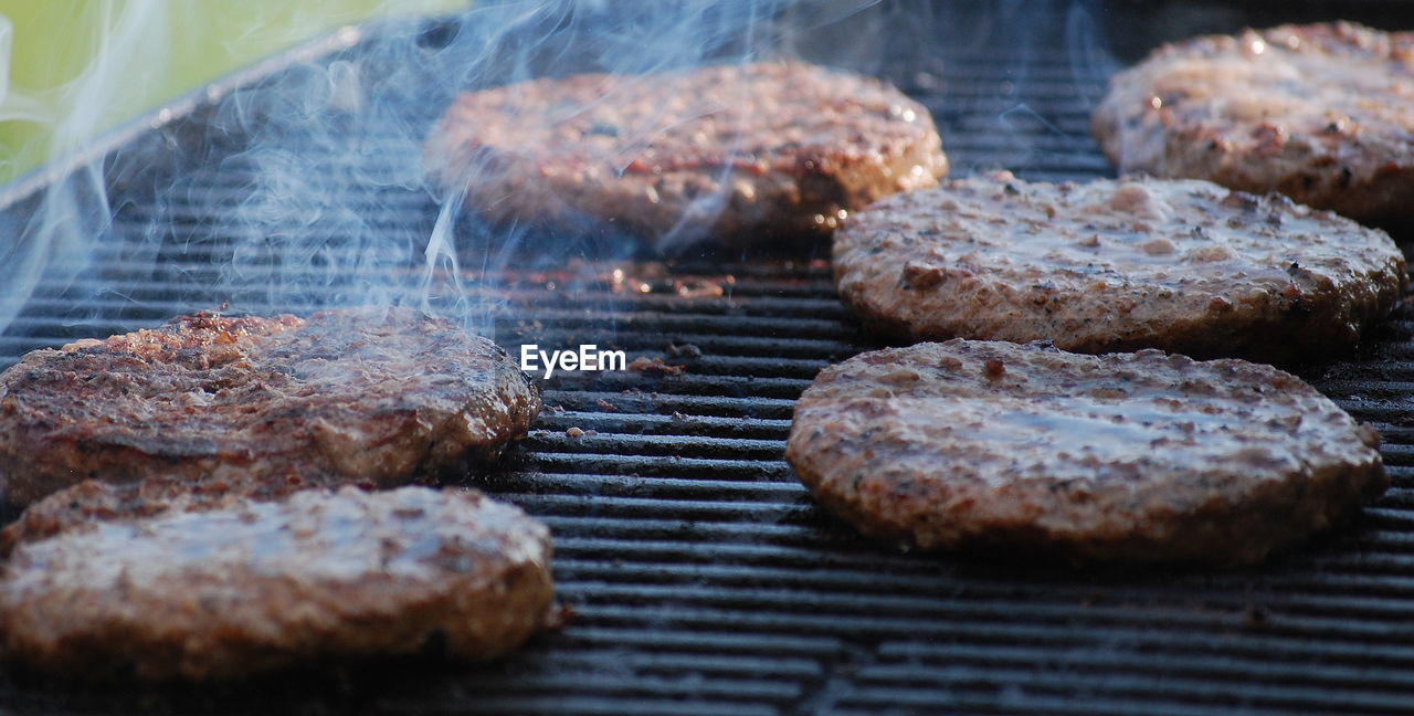 CLOSE-UP OF MEAT COOKING ON BARBECUE