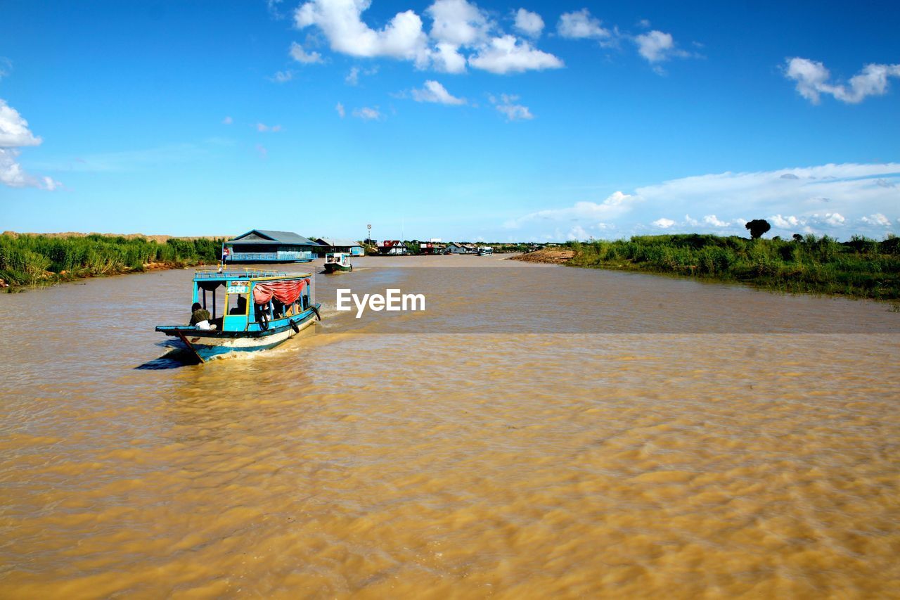 BOAT IN RIVER AGAINST SKY