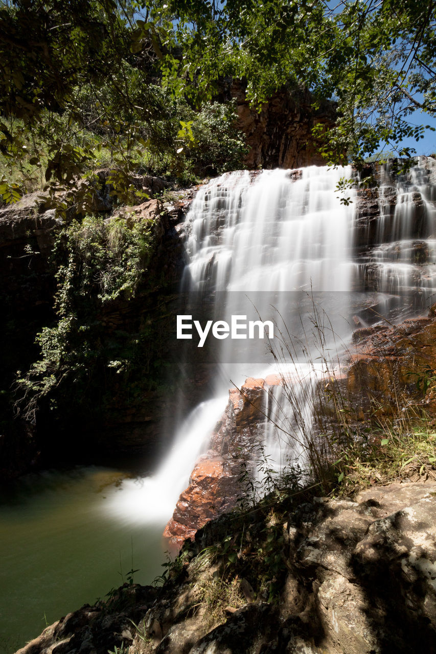 SCENIC VIEW OF WATERFALL AGAINST TREES