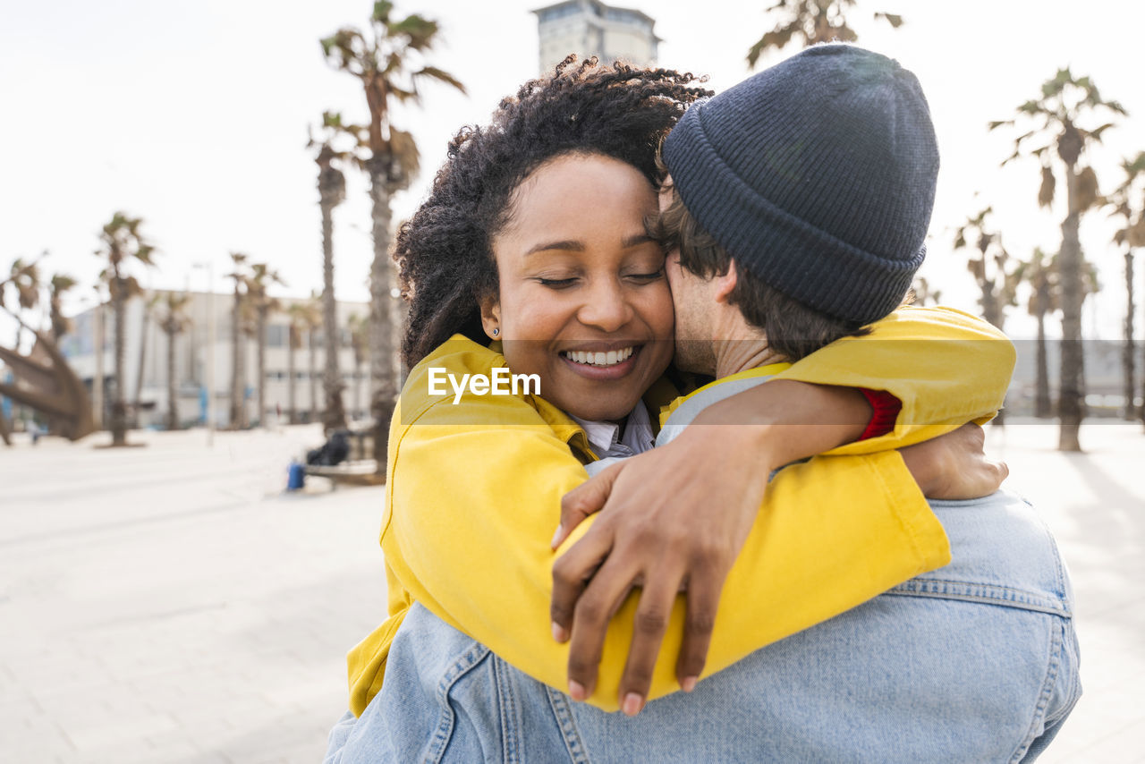 Smiling afro woman hugging man