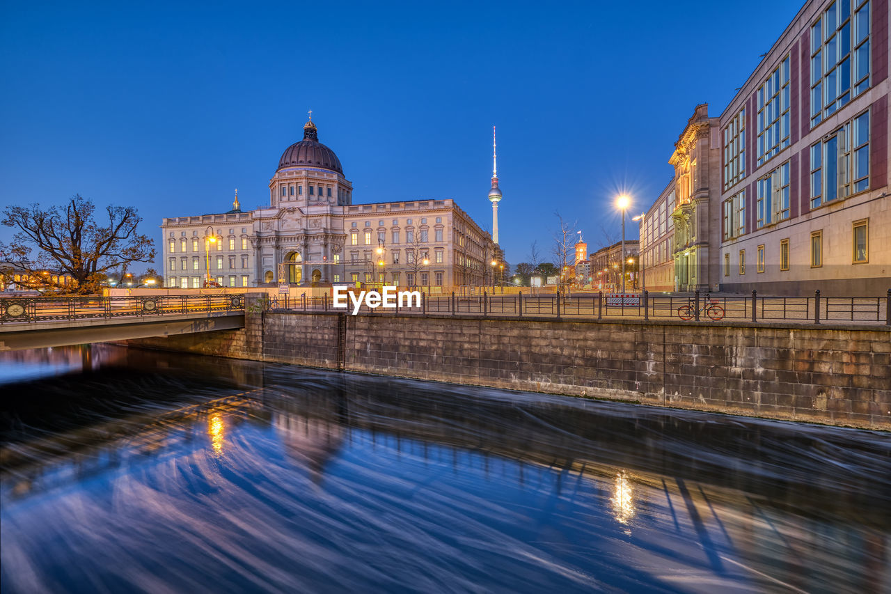 The reconstructed berlin palace with the television tower at the blue hour