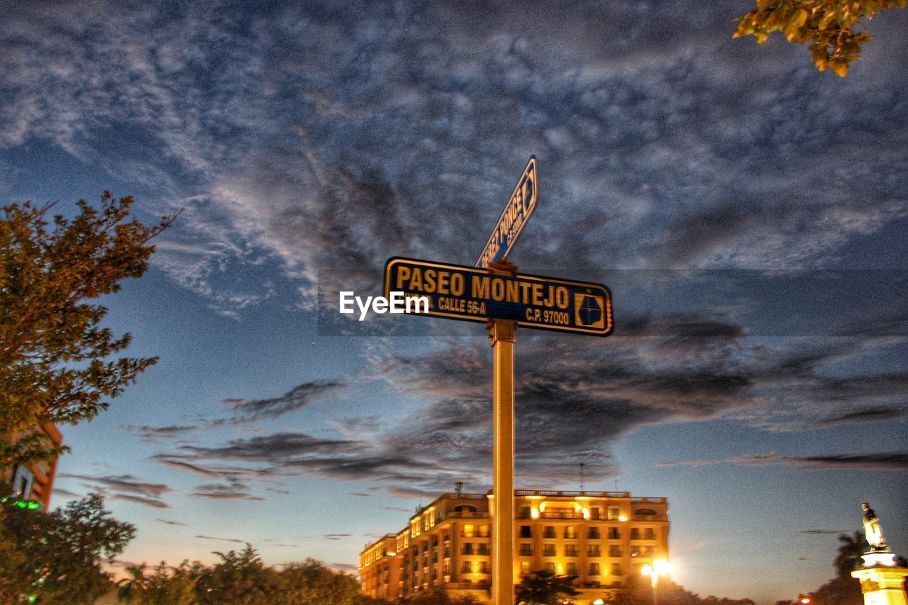 LOW ANGLE VIEW OF ROAD SIGNS AGAINST SKY AT SUNSET