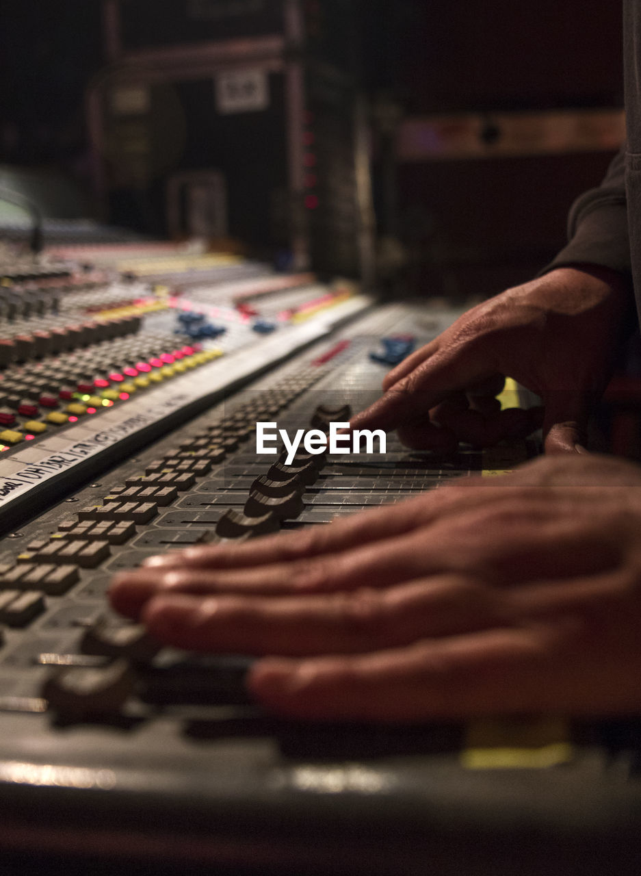 Cropped hands of dj using sound mixer