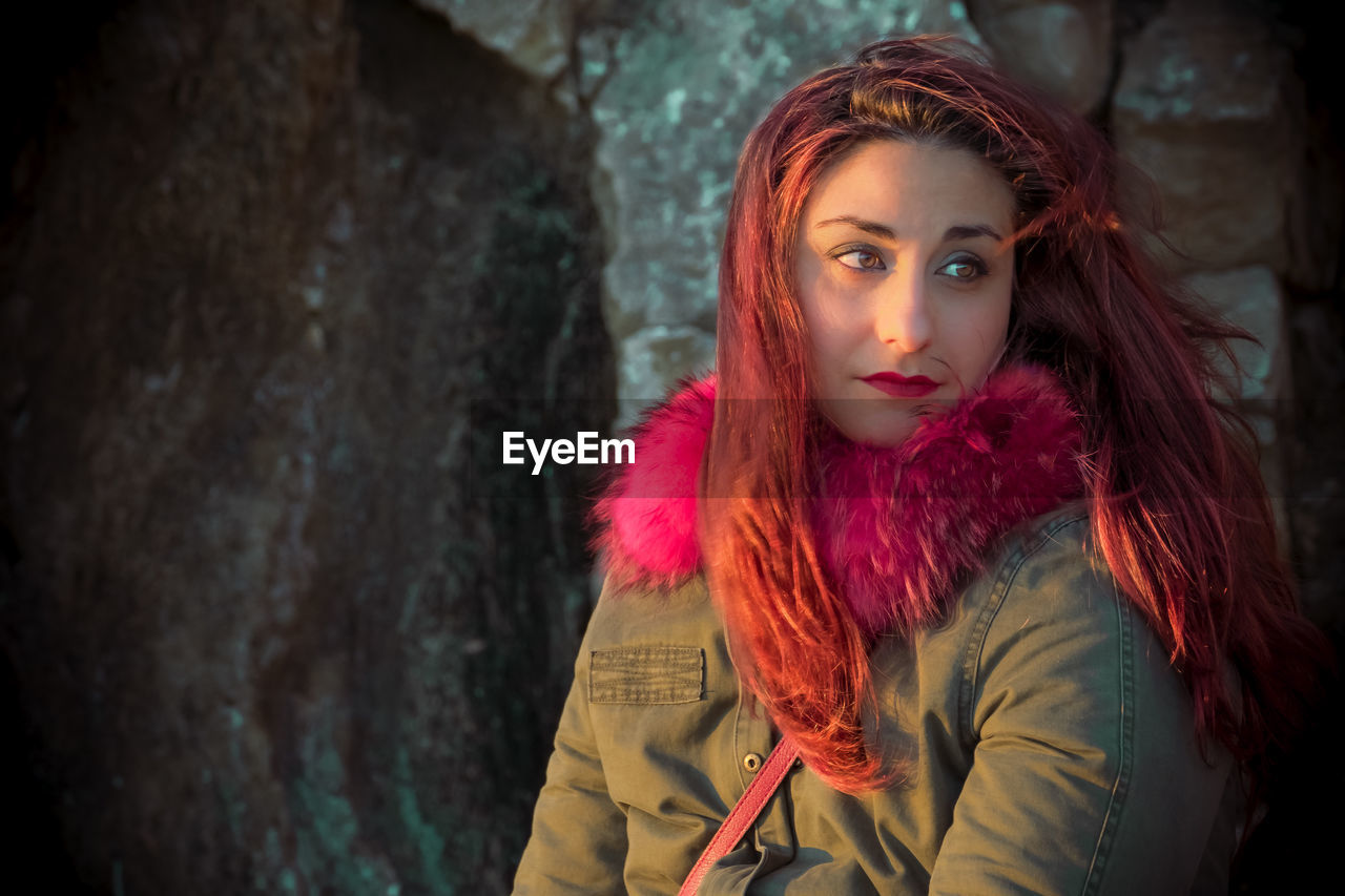 Beautiful redhead woman against rock formation