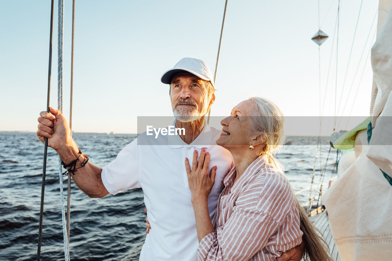 Rear view of people on boat sailing in sea