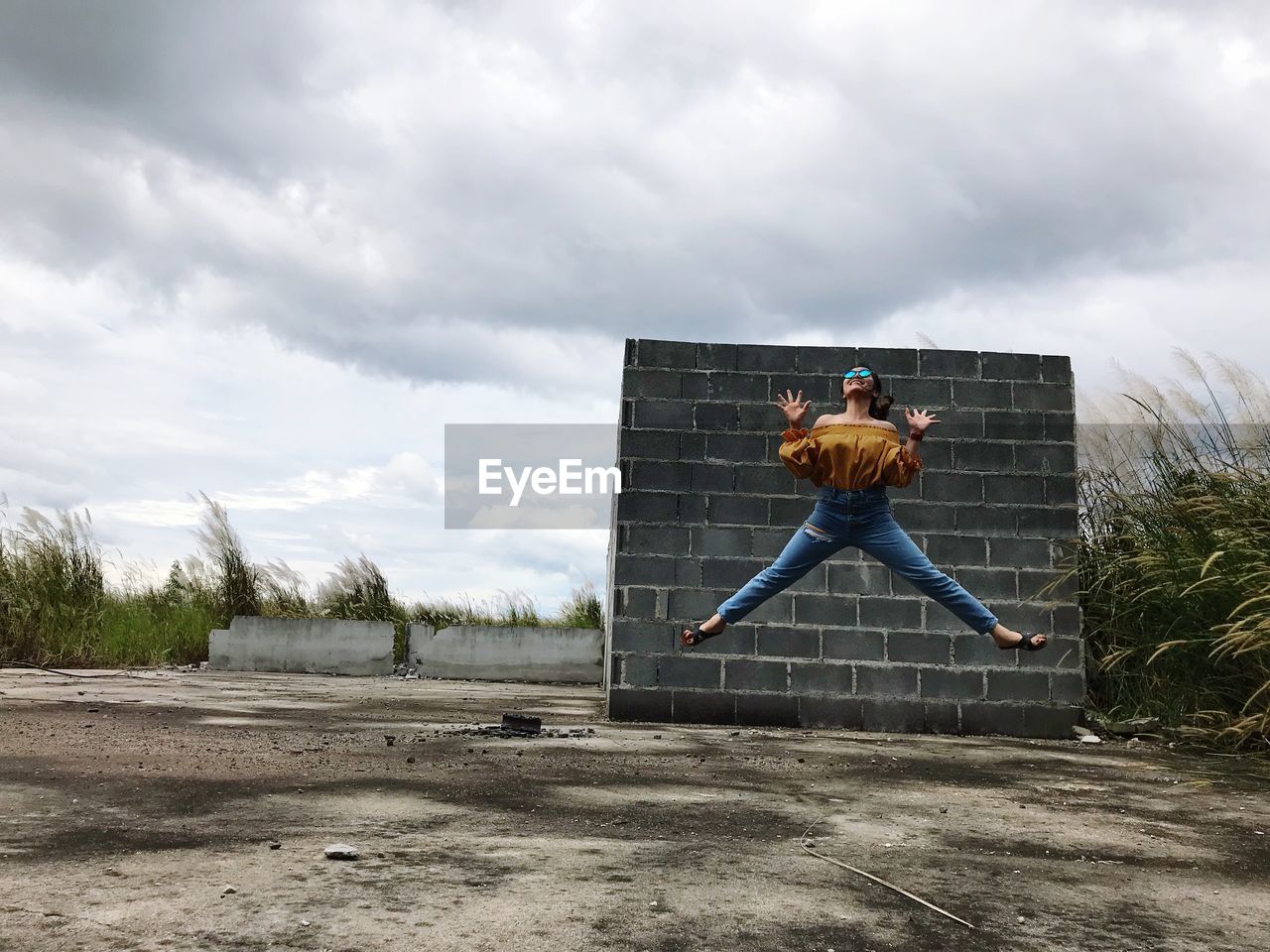 Full length of woman jumping on land against sky