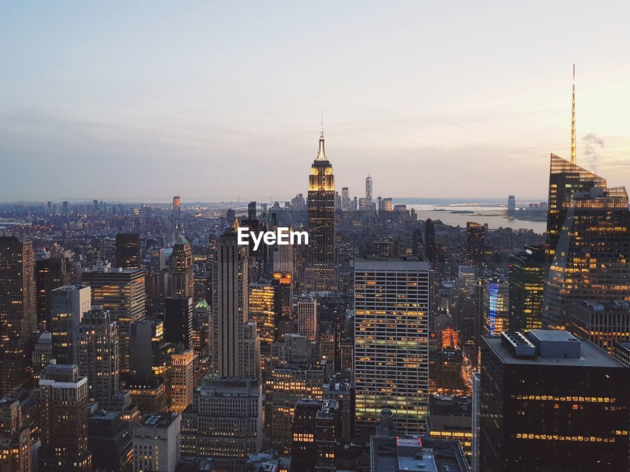 Aerial view of city lit up against sky