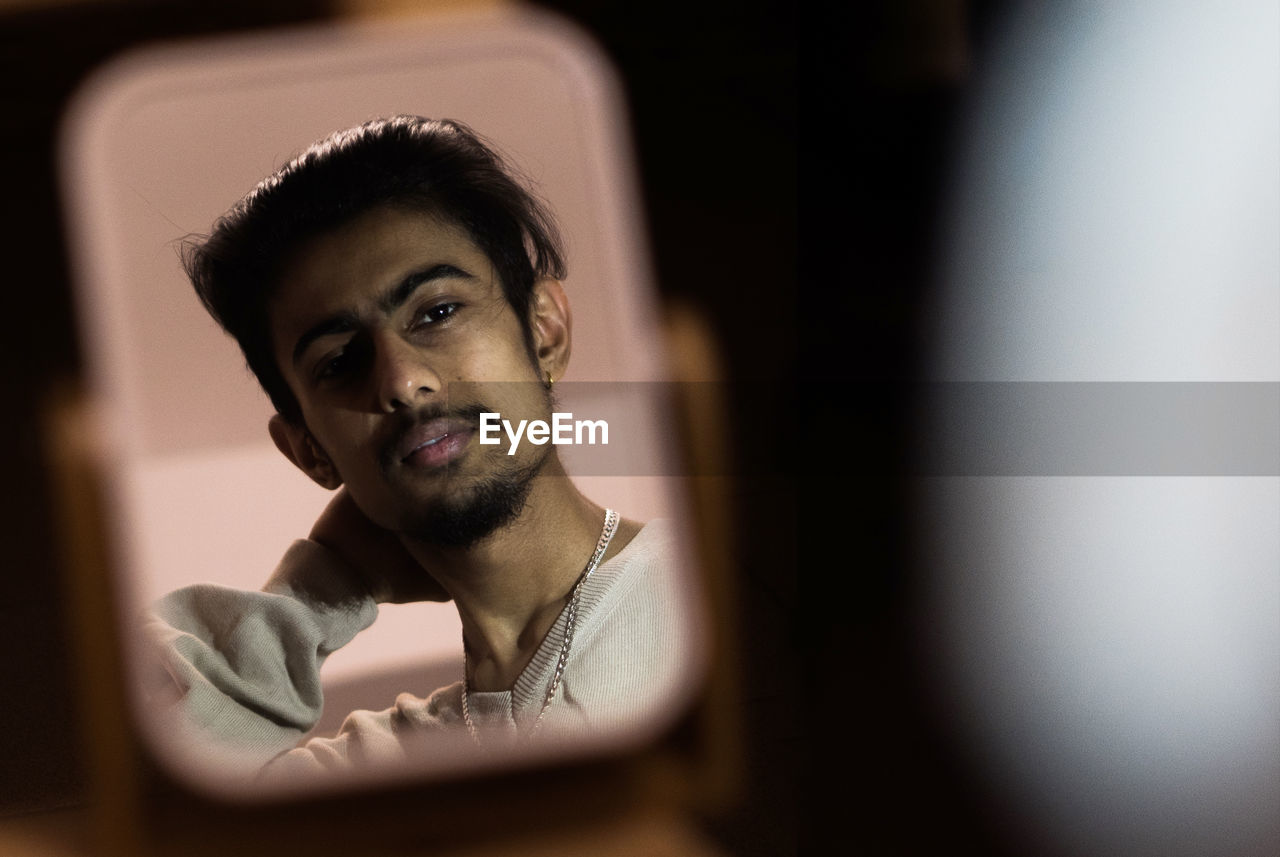 Portrait of young man reflection in mirror