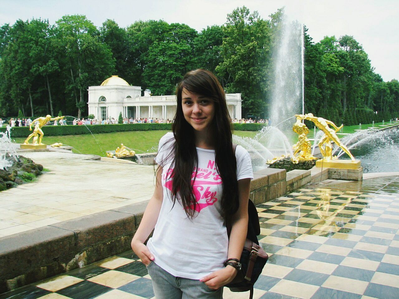 PORTRAIT OF A SMILING YOUNG WOMAN WITH WATER IN PARK