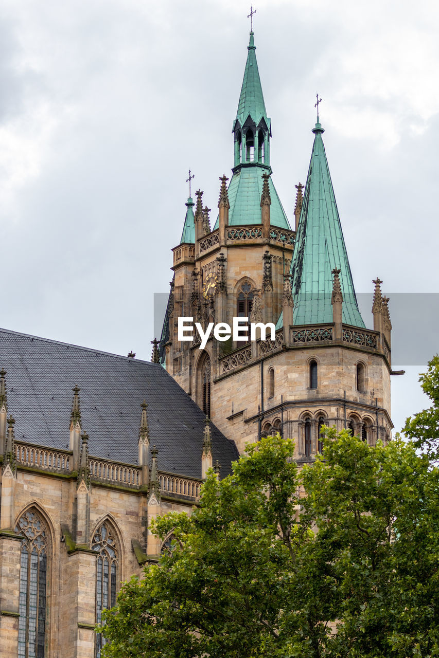 View of the towers of the cathedral in erfurt with green tree in the foreground