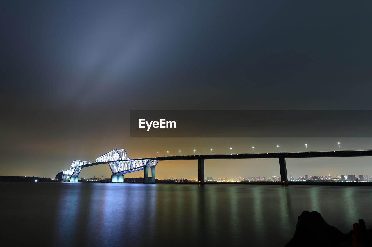 Bridge over sea against sky at night