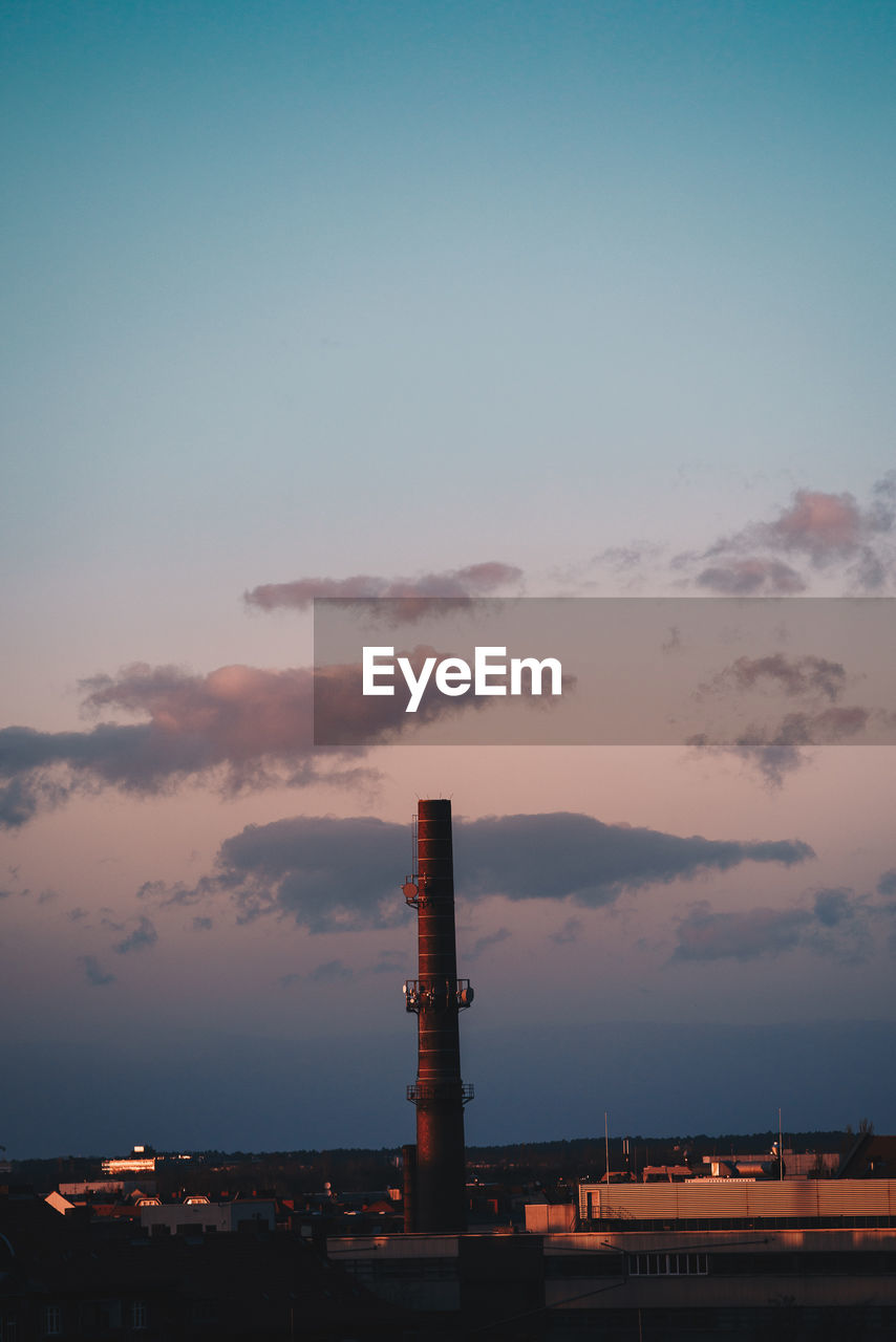 SMOKE STACK AGAINST SKY AT SUNSET