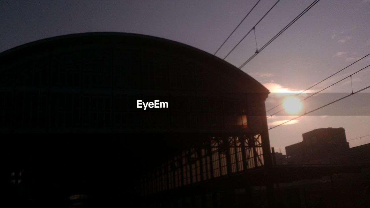 Low angle view of train shed against sky during sunset