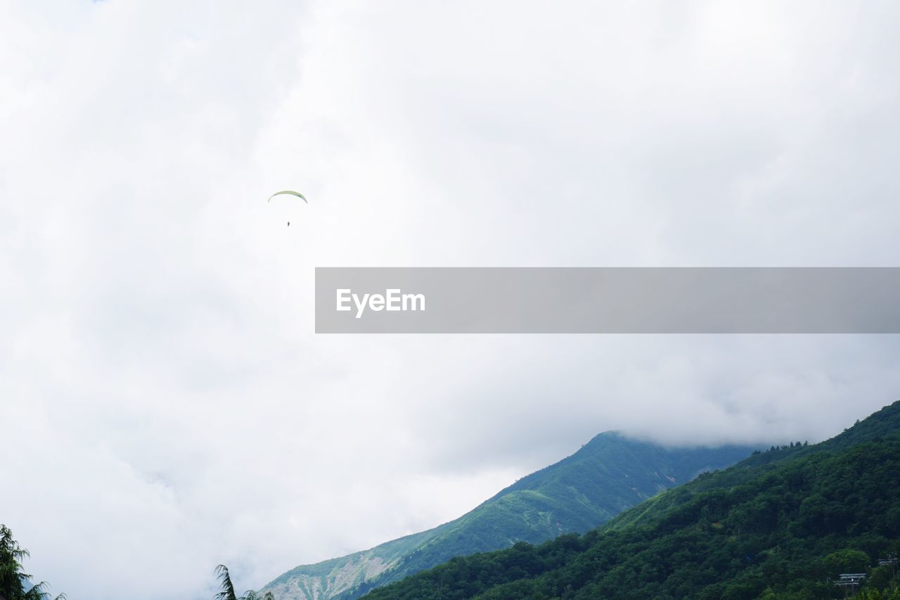 LOW ANGLE VIEW OF PERSON FLYING IN SKY