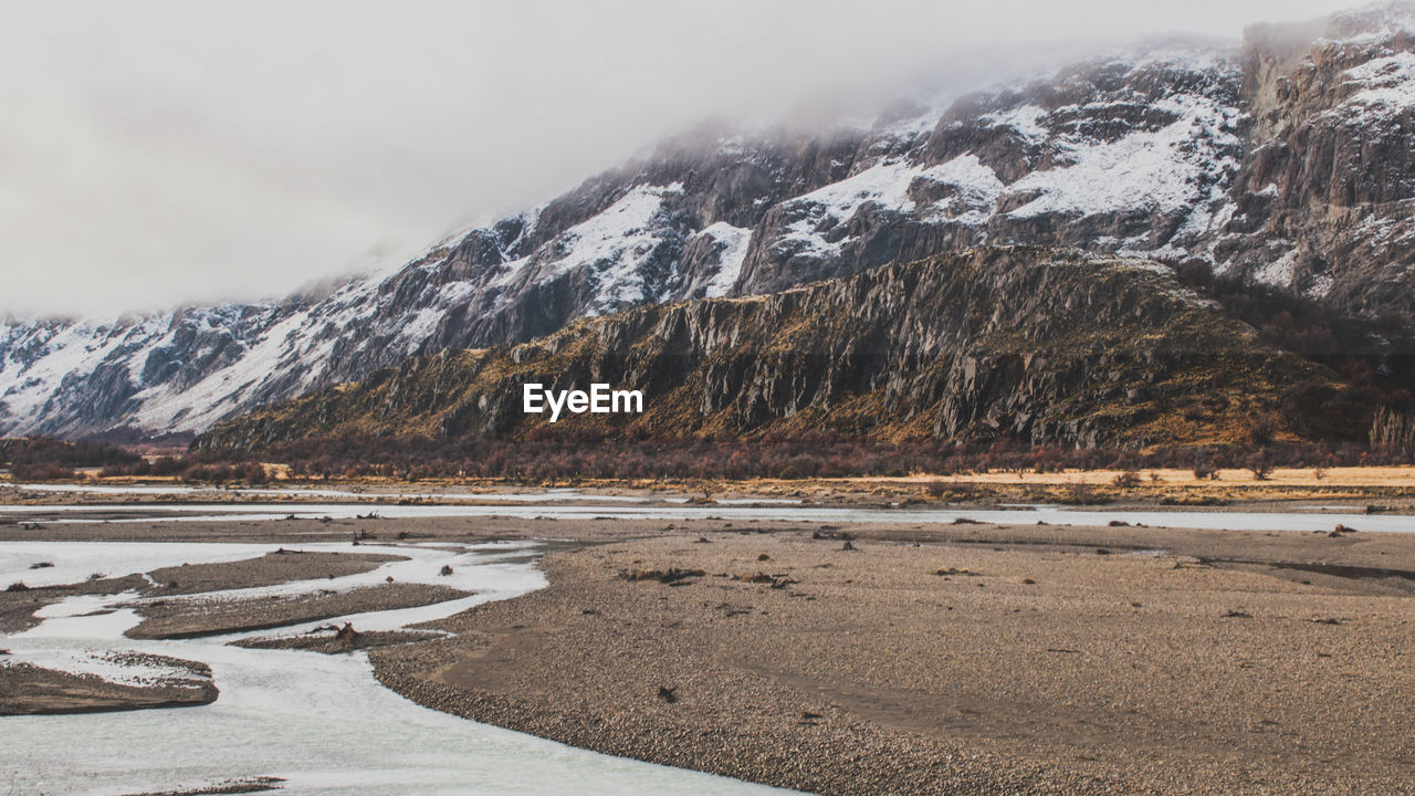 SCENIC VIEW OF MOUNTAINS AGAINST SKY DURING WINTER