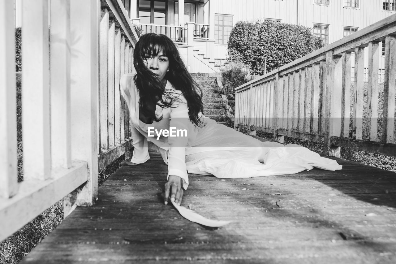 Portrait of woman sitting on footpath
