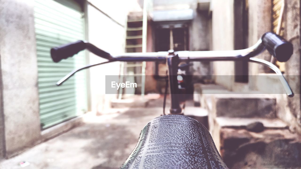 Low section of bicycle on street against buildings