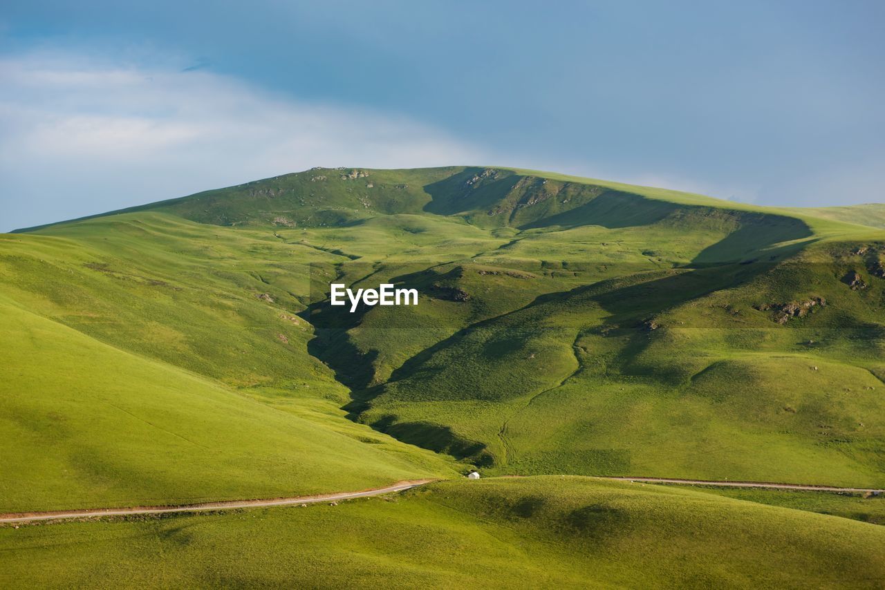 Scenic view of green landscape against sky