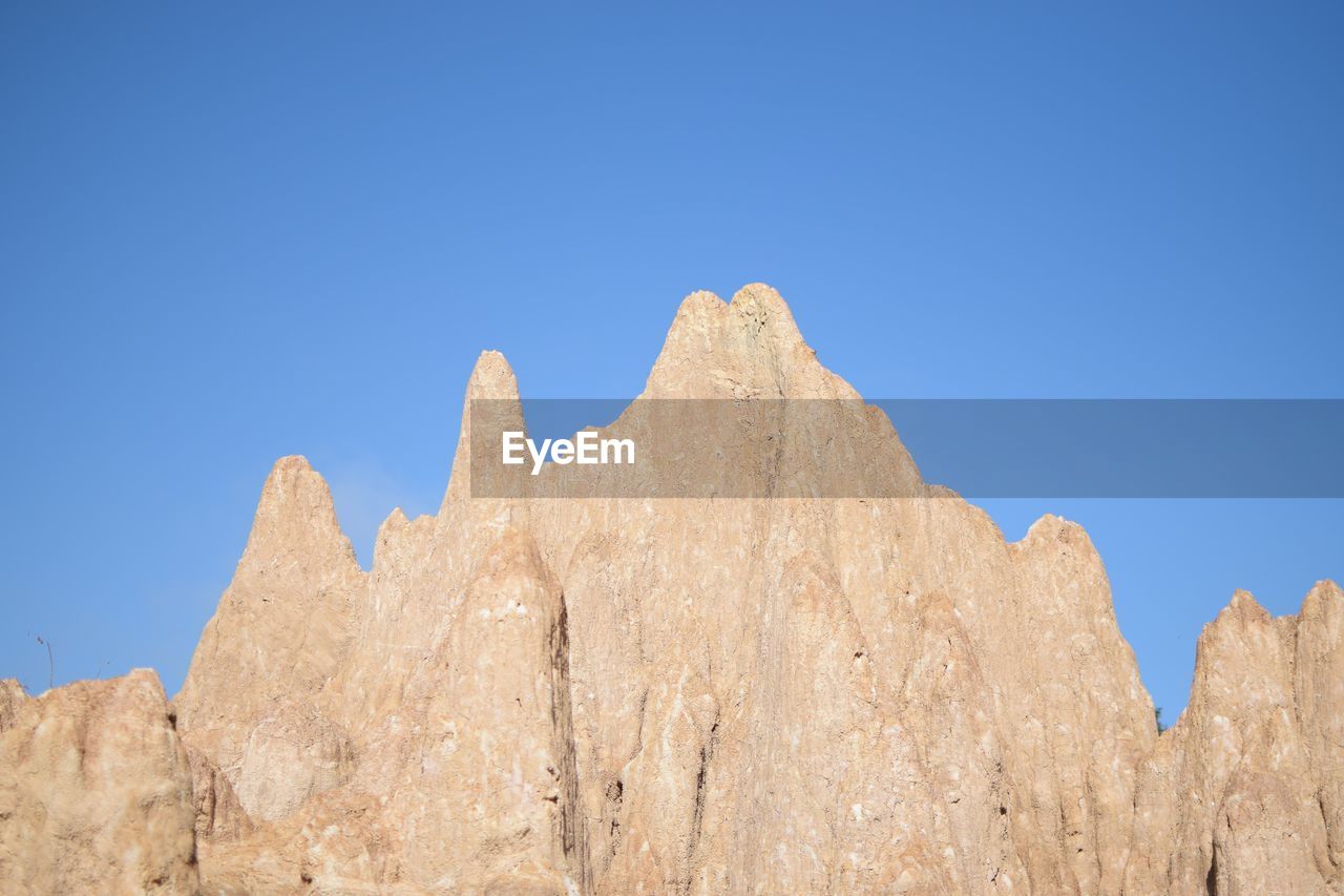 LOW ANGLE VIEW OF ROCKS AGAINST BLUE SKY