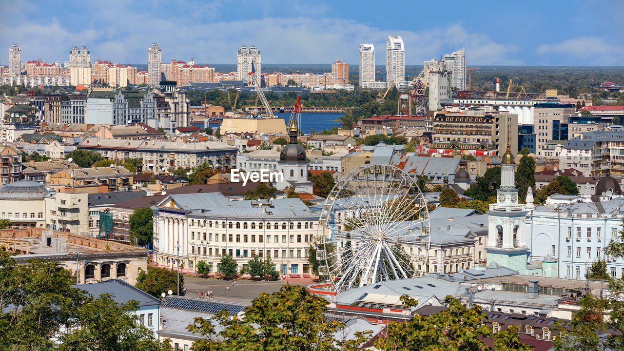 The landscape of the summer city of kyiv overlooking the old district of podil with a ferris wheel. 