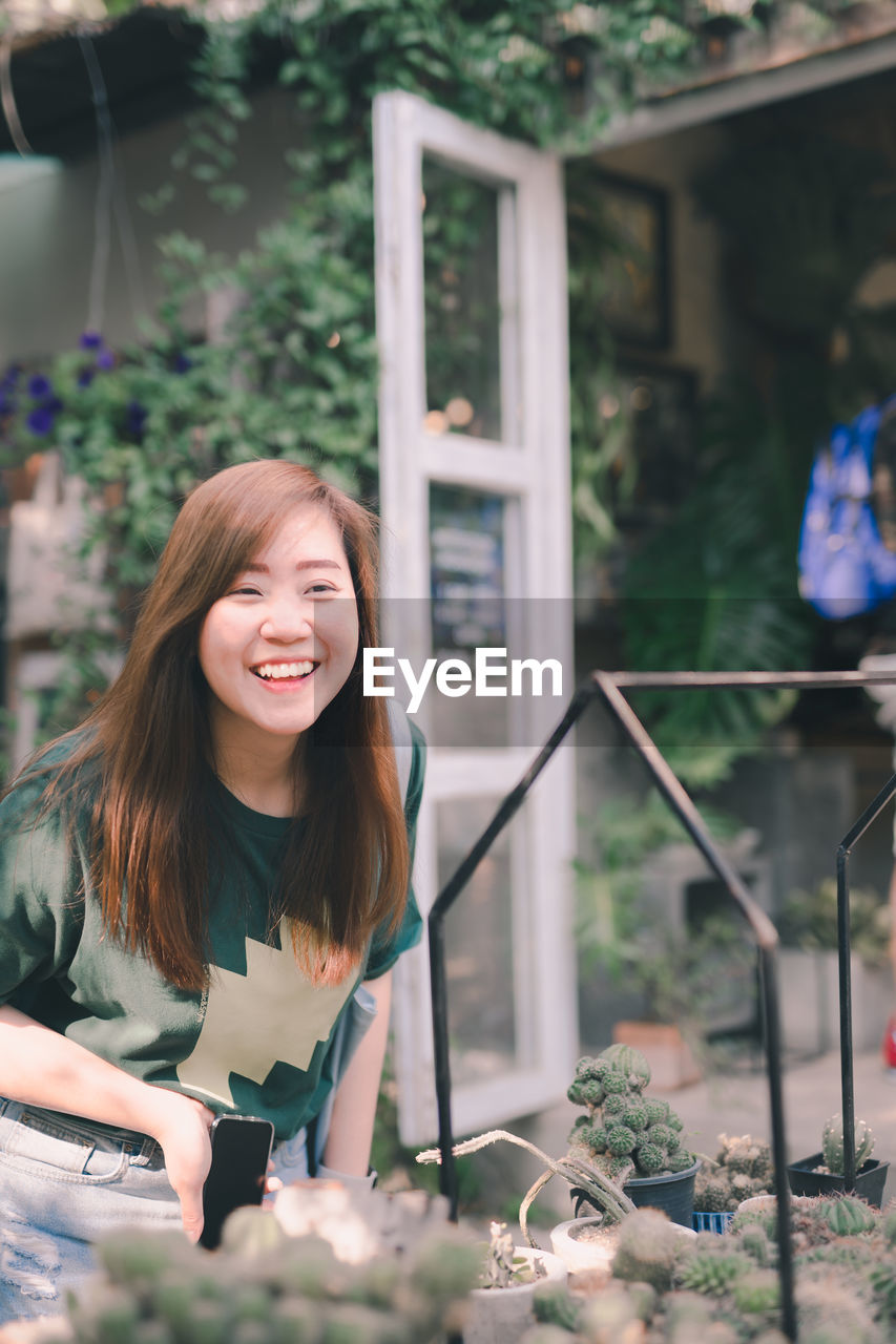 Asian woman with smile and happy for plant care at her home