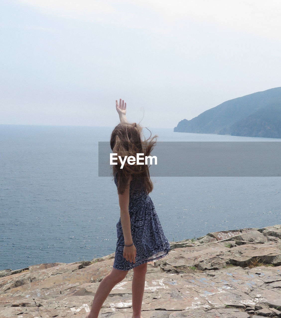 Full length of woman standing on sea shore against sky