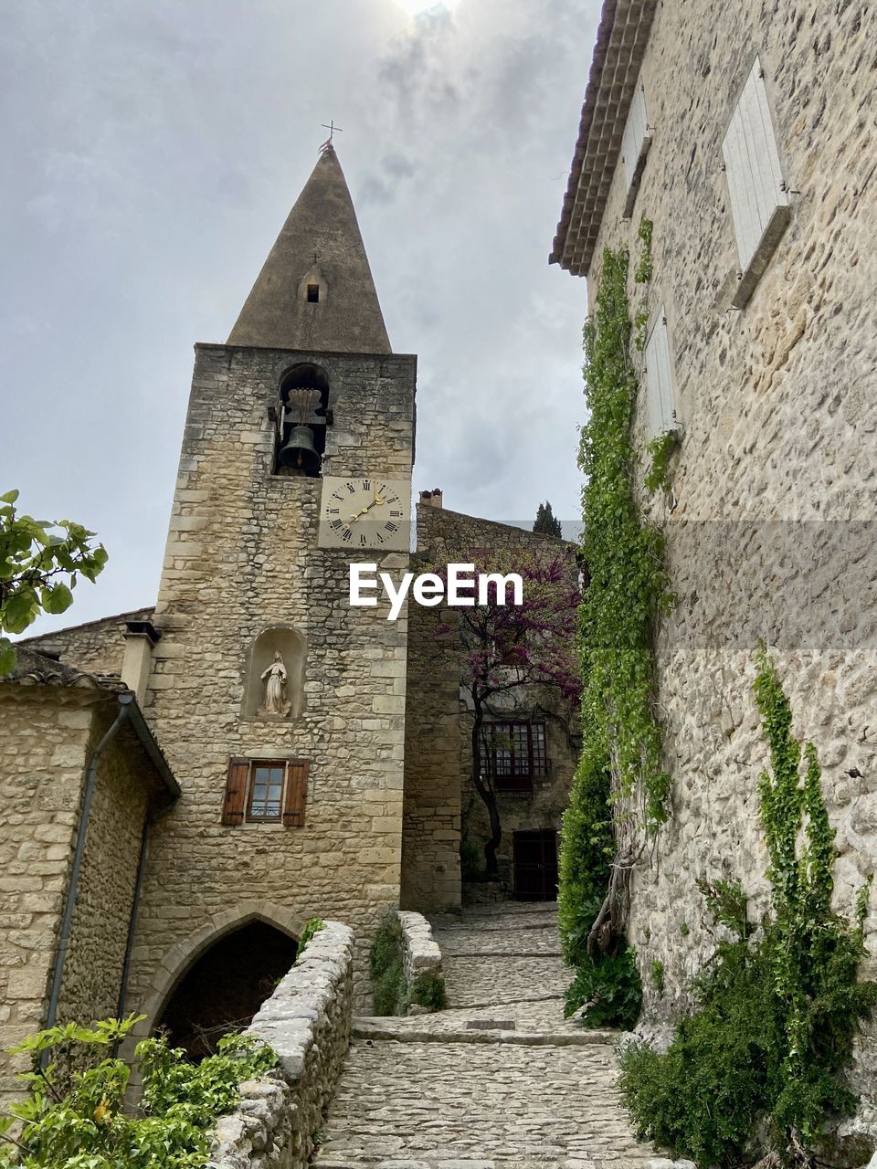architecture, built structure, building exterior, building, village, history, the past, nature, place of worship, religion, tower, sky, château, plant, no people, estate, travel destinations, cloud, old, stone material, belief, house, wall, spirituality, outdoors, tree, medieval, day, low angle view, travel, residential district, castle, tourism, rural area, cottage, wall - building feature
