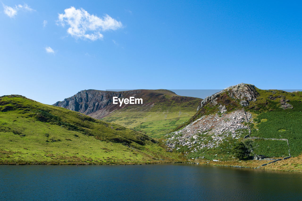 SCENIC VIEW OF LAKE BY MOUNTAIN AGAINST BLUE SKY