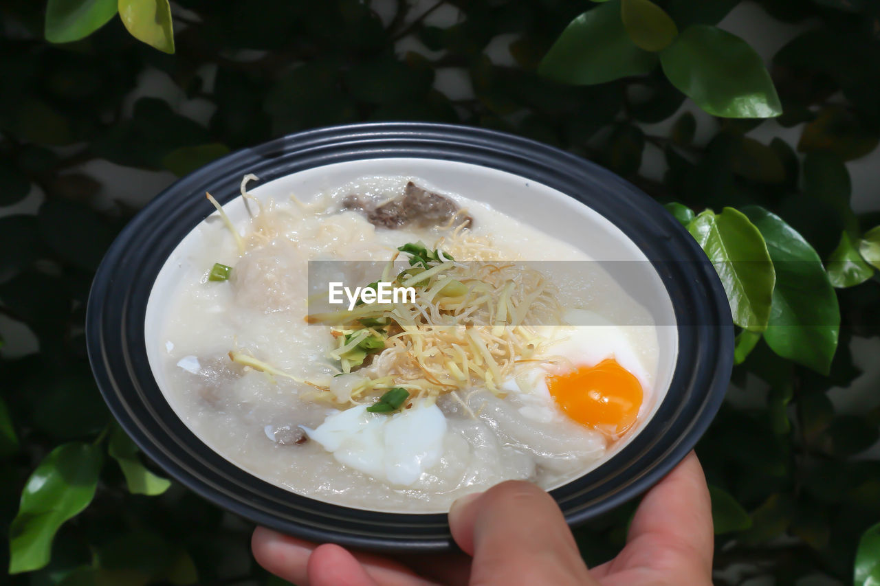 HIGH ANGLE VIEW OF PERSON HOLDING FOOD