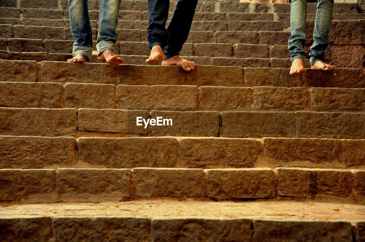 LOW SECTION OF WOMEN WALKING ON STAIRCASE