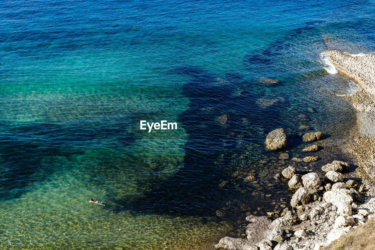 HIGH ANGLE VIEW OF ROCKS ON SHORE