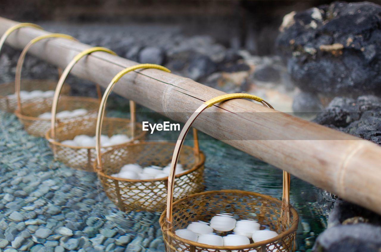 HIGH ANGLE VIEW OF WICKER BASKET ON PEBBLES