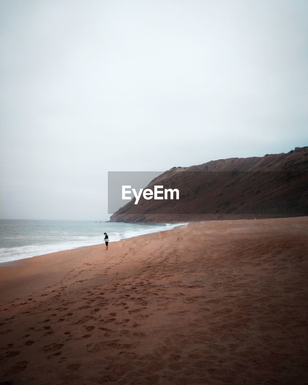 SCENIC VIEW OF BEACH AND MOUNTAINS AGAINST CLEAR SKY