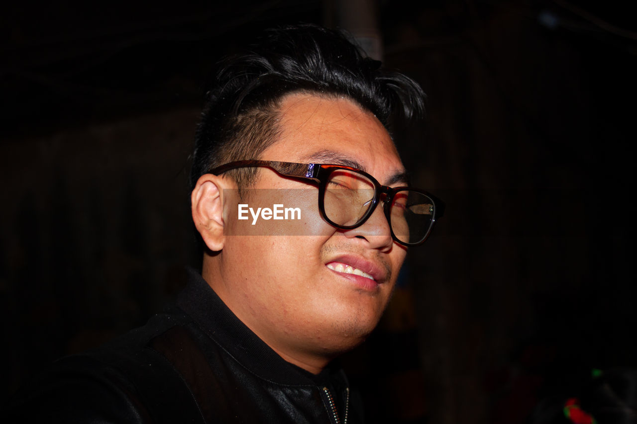 Man winking against black background