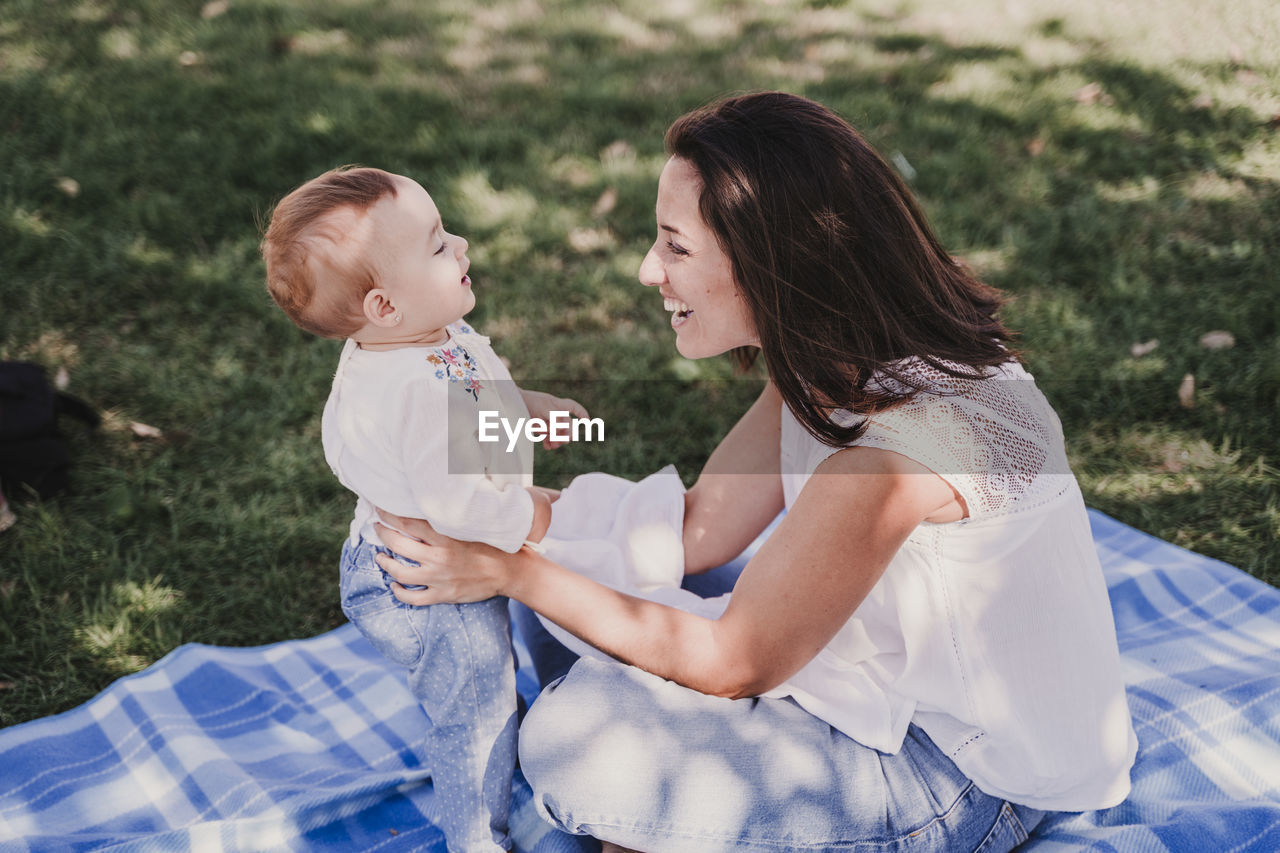 Woman playing with baby girl at park