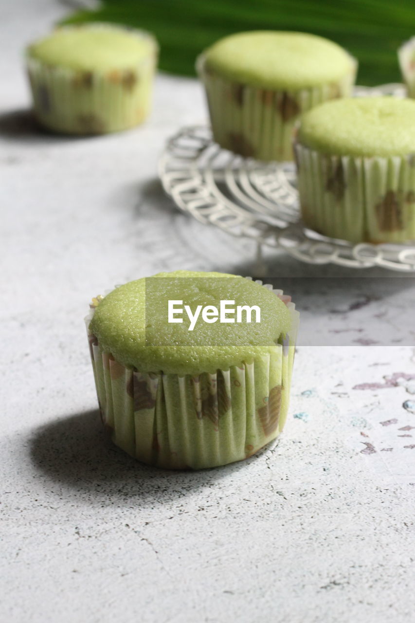 CLOSE-UP OF CUPCAKES ON TABLE WITH SPOON