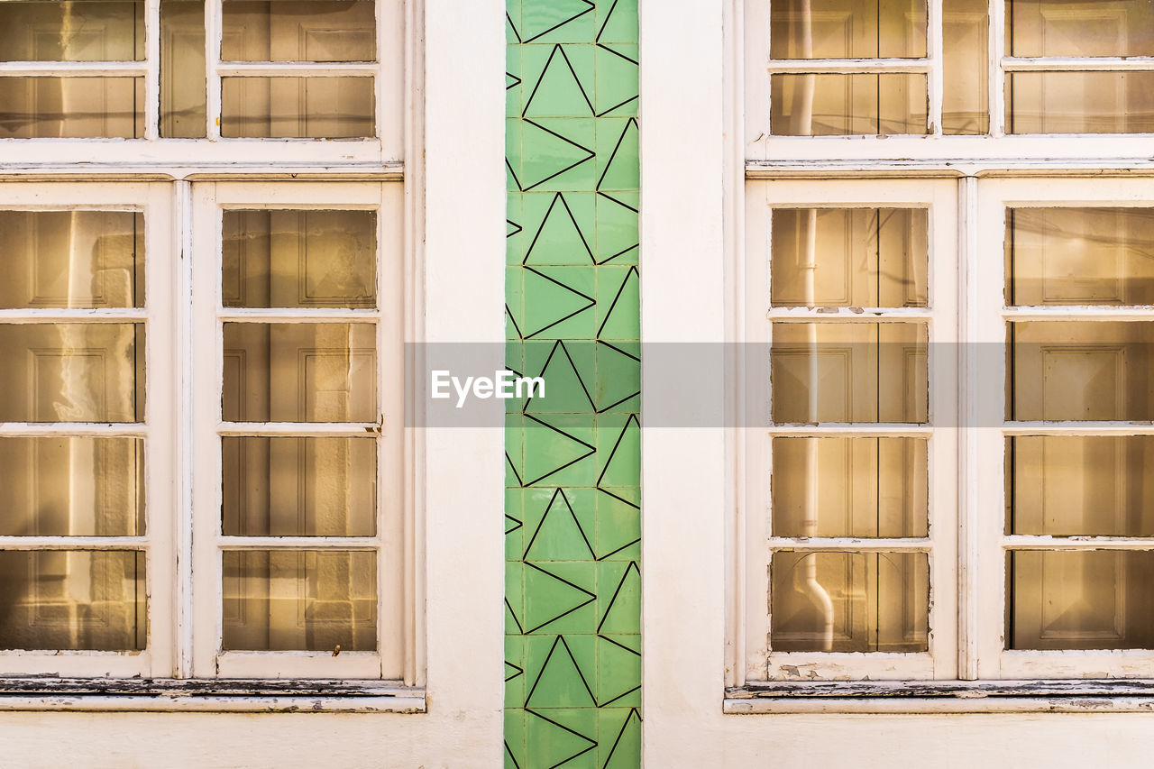 Facade of an old house in aveiro white wooden windows decorated by portuguese tiles in green