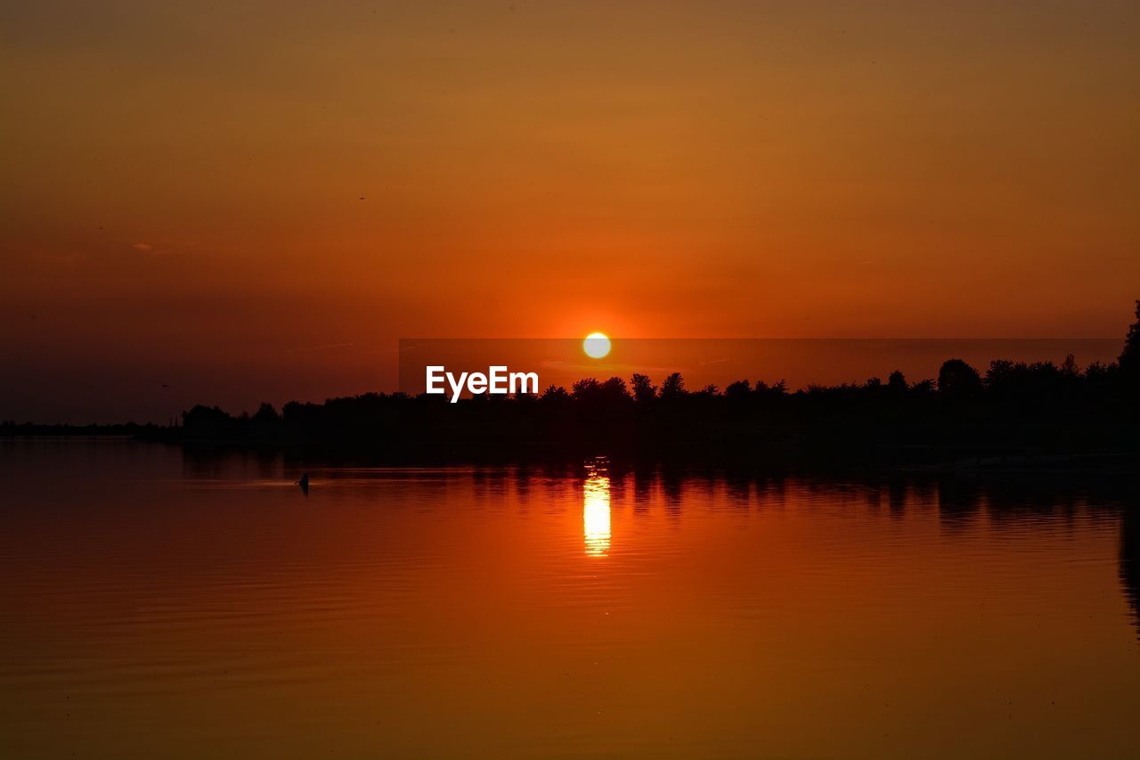 Scenic view of lake against sky during sunset