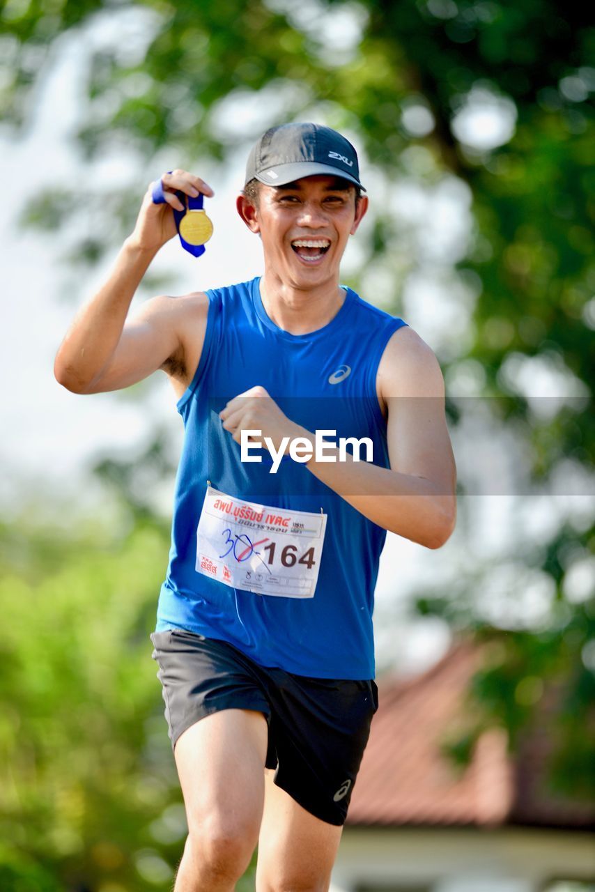 PORTRAIT OF SMILING MAN WITH ARMS OUTSTRETCHED