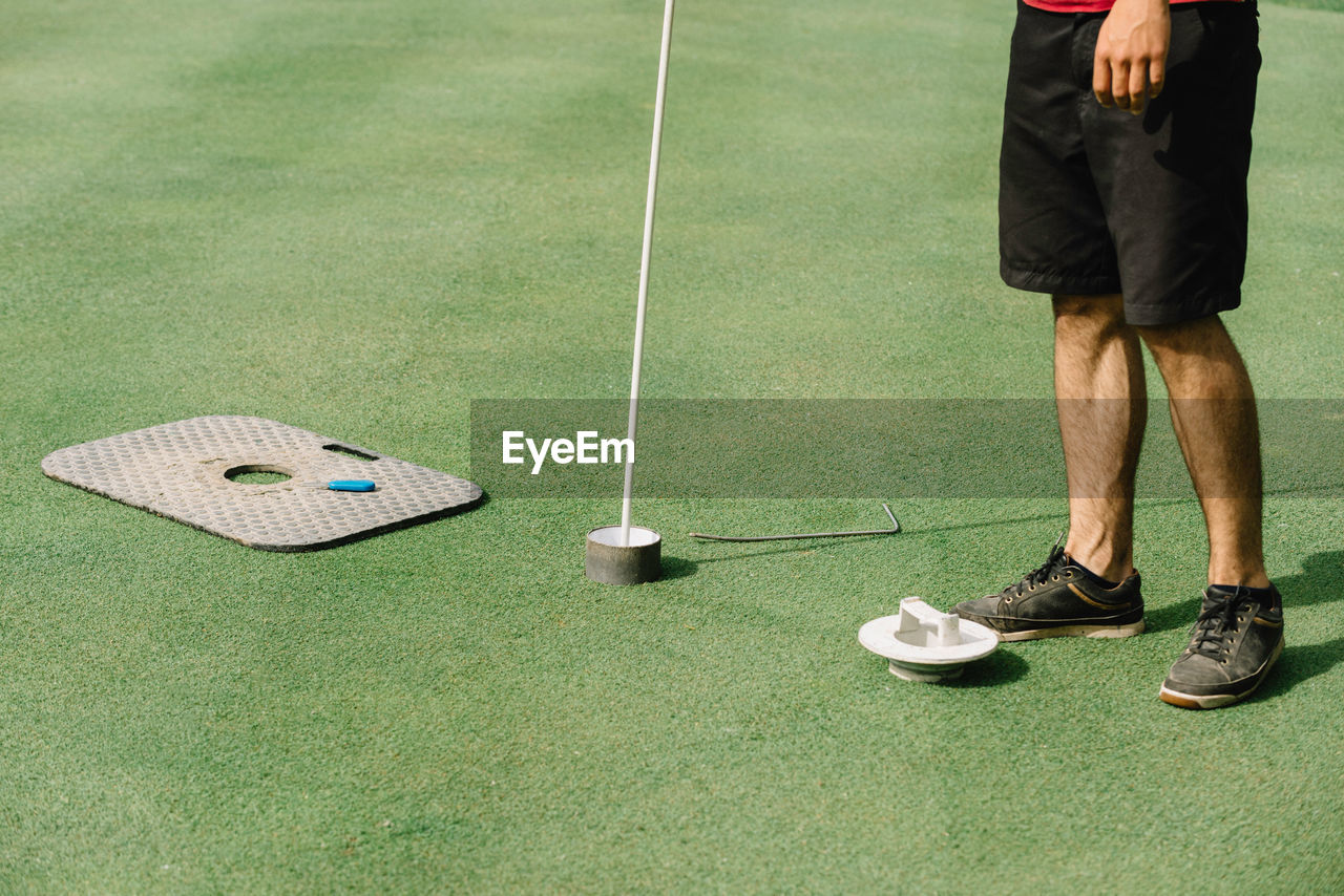 Low section of man standing on golf course